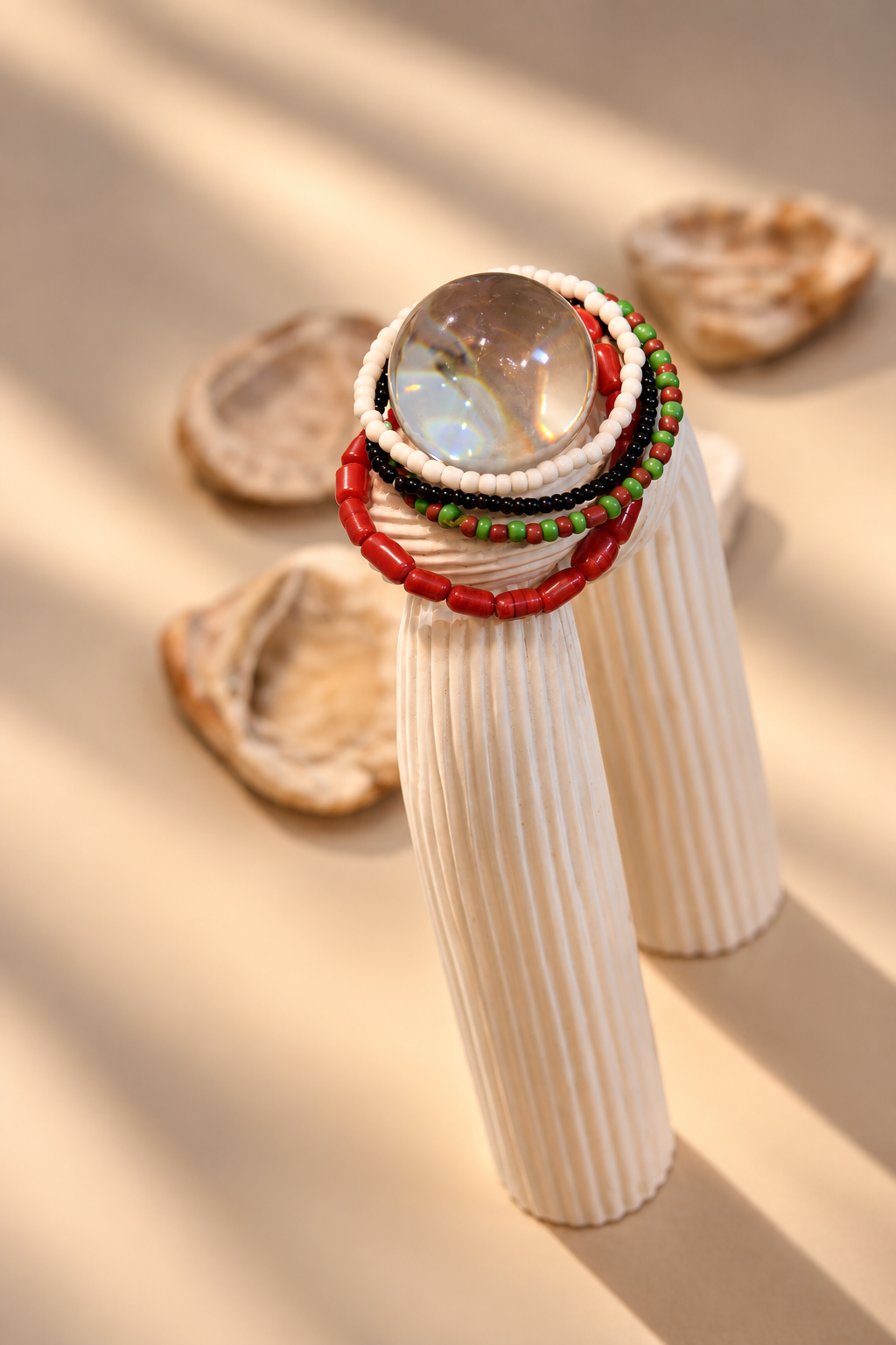 Three-strand coral, white, and green bead bracelet on wrist